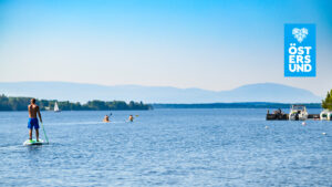 Vy över storsjön sommartid med båtar, paddleboard och kajaker