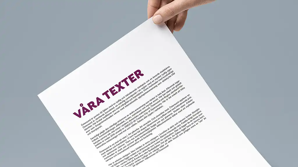 hand håller i ett pappersark med rubriken våra texter